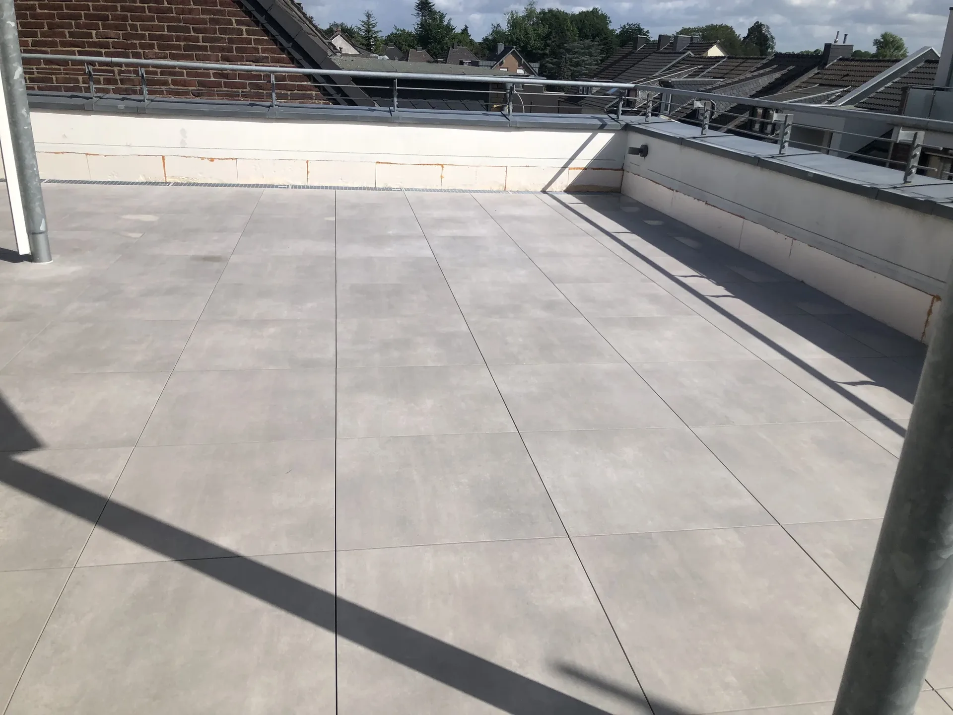 Dachterrasse mit großformatigen grauen Platten Dachterrasse mit großformatigen grauen Platten